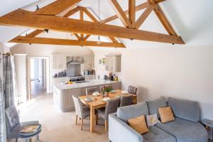 a kitchen and living room with a table and a couch at Filby Barn by Big Skies Cottages in Docking