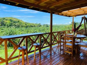 a deck with chairs and tables and a view at Cabaña tolle Vista in Savegre