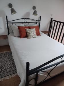 ein Bett mit roten und weißen Kissen darauf in der Unterkunft Studio privé avec terrasse entrée indépendante in Saint-Nazaire