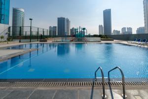 a large swimming pool with a city skyline in the background at S Plaza Suites Hotel in Manama