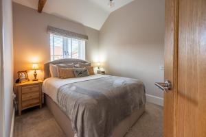 a bedroom with a large bed and a window at Filby Barn by Big Skies Cottages in Docking