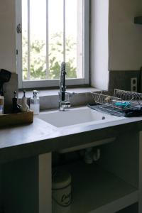 um lavatório branco numa cozinha com uma janela em Charming Loft in the countryside of Althen des Paluds em Althen-des-Paluds
