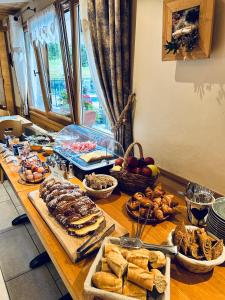 una mesa con varios tipos de pan y otros alimentos en Hameau des Prodains - Hôtel, en Morzine