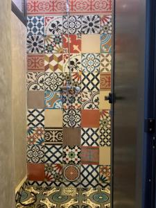 a door with a wall of different colored tiles at Hostel The Endless House Anchor point in Taghazout