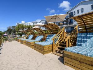 a row of lounge chairs on the beach at Margate Beach Club in Margate