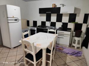 Residencial Ramos في توريس: مطبخ مع ثلاجة وطاولة وكراسي