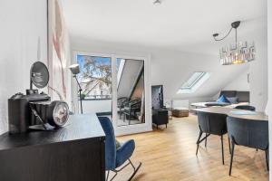 a living room with a table and chairs in a room at ANYTIME - Apartments in Langenargen in Langenargen