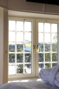 a bedroom with two windows with a view of the ocean at Grand Hotel Saltsjöbaden in Saltsjöbaden