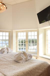 a bedroom with two beds with windows and a flat screen tv at Grand Hotel Saltsj&ouml;baden in Saltsj&ouml;baden