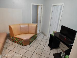 een leren stoel in een woonkamer met een televisie bij Residencial Ramos in Torres