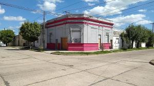 um edifício rosa e branco na esquina de uma rua em The Rustic Hause 2 em Gualeguay