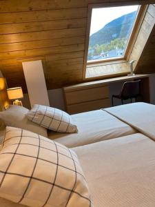 two beds in a room with a window at A 25 m. del Telecabina de Pal in La Massana