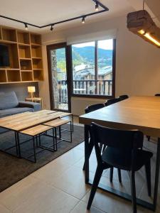 - un salon avec une table, des chaises et un canapé dans l'établissement A 25 m. del Telecabina de Pal, à La Massana