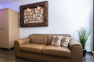 brązowa kanapa w salonie z lustrem w obiekcie Rent like home - Strzelców 24C w mieście Kościelisko