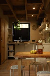 a kitchen with a table and stools and a window at Domek SzumiSosna2 in Życiny
