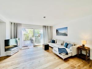 a living room with a couch and a tv at Ferienhaus "Eenhoorn" in Dierhagen