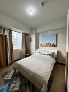1 dormitorio con 1 cama grande y una pintura en la pared en Manhattan Heights TowerB in Araneta Cubao 5mins walk to Smart Araneta, en Manila