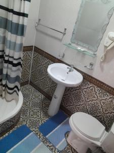 uma casa de banho com um lavatório, um WC e um espelho. em Hotel ravshan em Bukhara