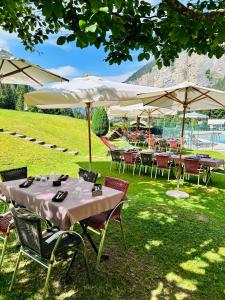 a group of tables and chairs with umbrellas at Hameau des Prodains - Hôtel in Morzine