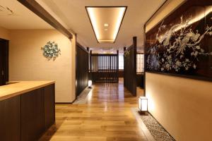 a hallway with wood floors and a lobby with lights at Mutsumikan in Gero