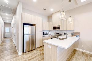 a kitchen with wooden cabinets and a stainless steel refrigerator at Uvalde Avenue Abode in McAllen