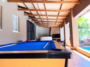 a pool table in a living room with a ceiling at Listos Guest House in Empangeni