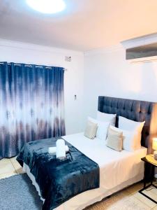 a bedroom with a bed with a blue curtain at Listos Guest House in Empangeni