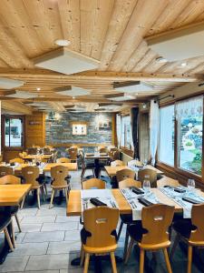 une salle à manger avec des tables et des chaises en bois dans l'établissement Hameau des Prodains - Hôtel, à Morzine