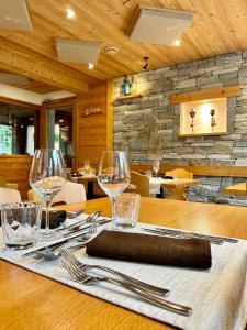 a wooden table with wine glasses and napkins on it at Hameau des Prodains - Hôtel in Morzine