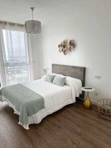 ein weißes Schlafzimmer mit einem großen Bett und einem Fenster in der Unterkunft Cies Sweet Home in Vigo