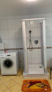 a bathroom with a washing machine and a washer at Ferienwohnung 1 Souterrainfenster in Hannover