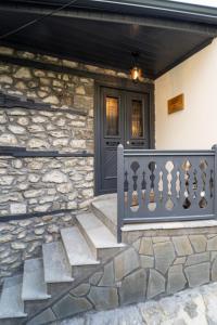 a stone house with a blue door and stairs at Dandy Villas Metsovo in Metsovo