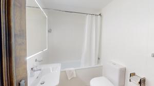 サンモリッツにあるMaria 8のトイレと洗面台を備えた白いバスルーム +10枚の写真