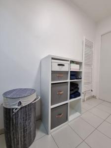 Un armario blanco con un cubo de basura en una habitación en CALME et COSY - proche Orly, en La Ville-du-Bois