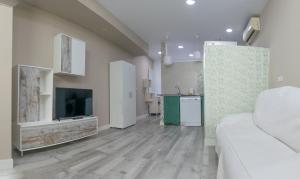 a living room with a white couch and a kitchen at Estudio en el pleno centro de Alicante by Renthas in Alicante