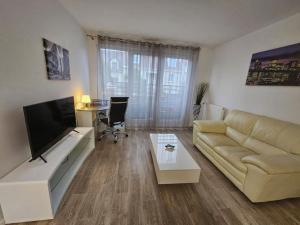 sala de estar con sofá y TV de pantalla plana en CALME et COSY - proche Orly, en La Ville-du-Bois