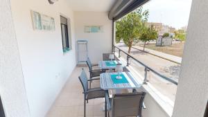 a balcony with tables and chairs and a view of a street at Holidoo Travel "Casa Calida" in Los Alcázares