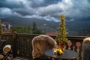 a table with a tree on top of a balcony at Dandy Villas Metsovo in Metsovo