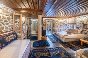 a bedroom with a bed and a stone wall at Dandy Villas Metsovo in Metsovo