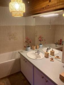 W łazience znajduje się umywalka, lustro i wanna. w obiekcie Longère de charme w mieście Saint-Cyran-du-Jambot