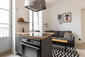 una cocina con fregadero y un sofá en una habitación en Dify Balcony - Quartier Ainay en Lyon
