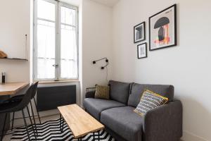 a living room with a couch and a table at Dify Balcony - Quartier Ainay in Lyon