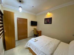 a bedroom with a bed and a desk and a television at MOK Apartments & Suites in Lagos