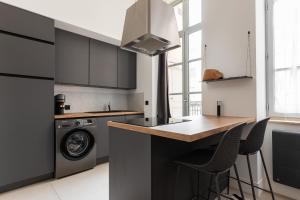 a kitchen with a washer and dryer next to a stove at Dify Balcony - Quartier Ainay in Lyon