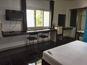 Zimmer mit 2 Stühlen und einem Schreibtisch mit einem TV in der Unterkunft Krabi Nemo House in Ao Nang Beach
