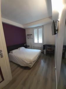 a bedroom with a white bed and a window at Au Spatial in Amiens