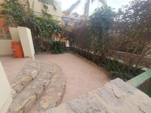 a backyard with a fence and a stone patio at CosmoCom Moradias Residence Capo Verde in Santa Maria