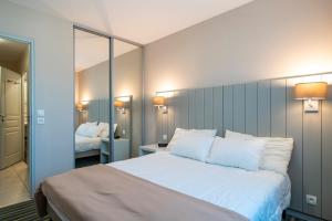 En eller flere senge i et værelse på Les Thermes 402 - Appt avec piscine commune + 6 billeder