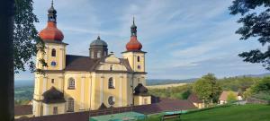 a church with two domes on top of a hill at Apartmán NOVOHRADKY 22 in Benešov nad Černou