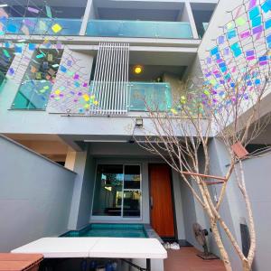 a house with a balcony and a swimming pool at Tainan Anping High Chill B&B in Anping